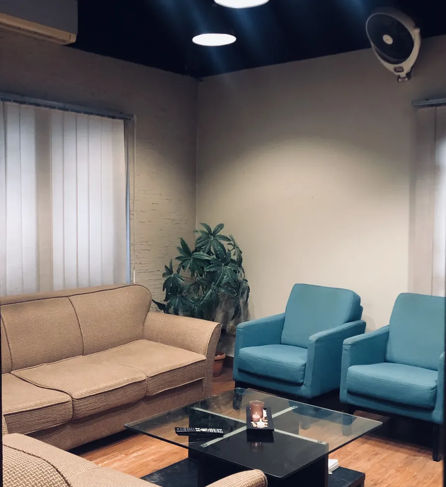 The Smile Savers lounge: teal armchairs, a sofa and soft evening light